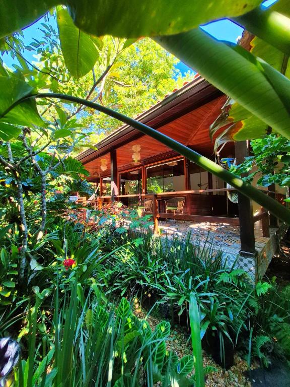 a house with a lot of plants in front of it at Aratinga Inn in Abraão