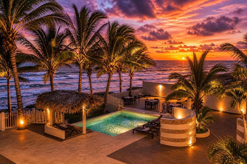a resort with a pool and palm trees and the ocean at Bon Jesus Hotel in Costa Esmeralda