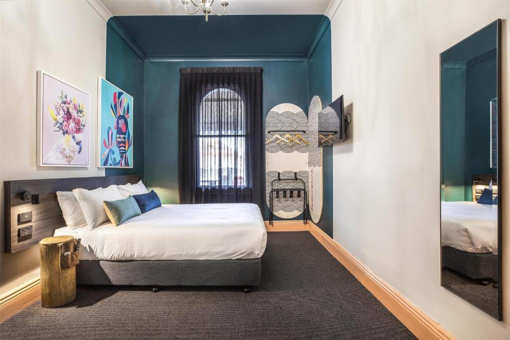 a bedroom with a large bed and a window at Ramsgate Hotel by Nightcap Social in Adelaide
