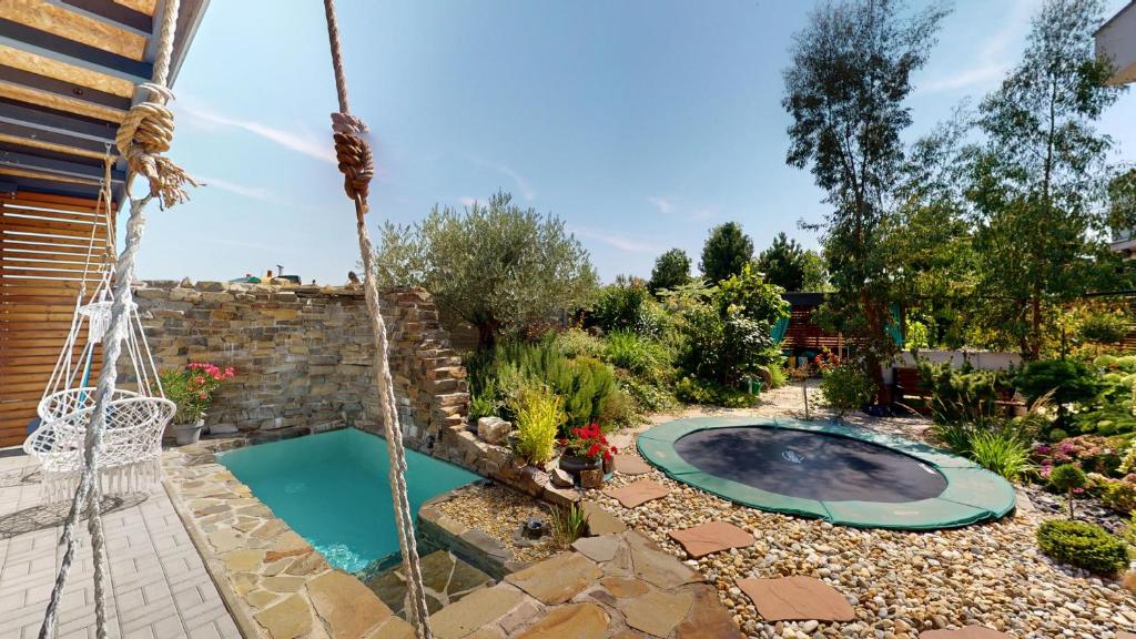 a swimming pool in a garden with a swing at Vila Golf & Relax, Hrubá Borša in Hrubá Borša