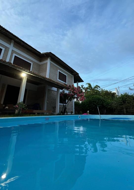 a house with a swimming pool in front of a house at Casa Brisa do Mar in Pipa