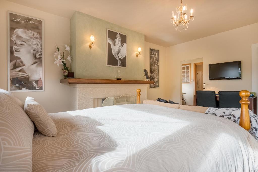 a bedroom with a large white bed and a tv at Jones On Wilson Boutique B&B in Burnie