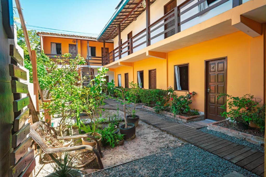 a courtyard of a house with chairs and plants at Tapirandú Pousada in Morro de São Paulo