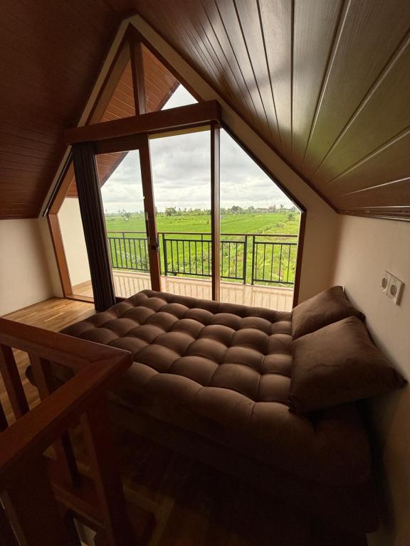 a large couch in a room with a large window at Adi Villa in Darmasaba