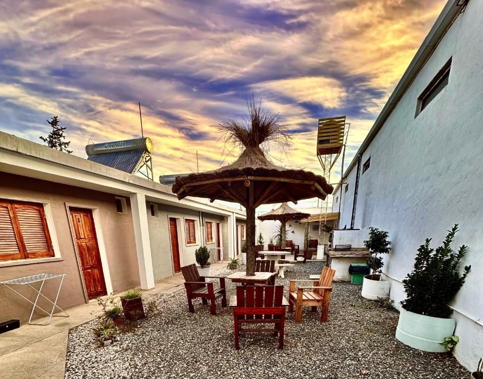 a patio with a table and chairs and an umbrella at Apart Piedras con cohera y desayuno seco in Villa María