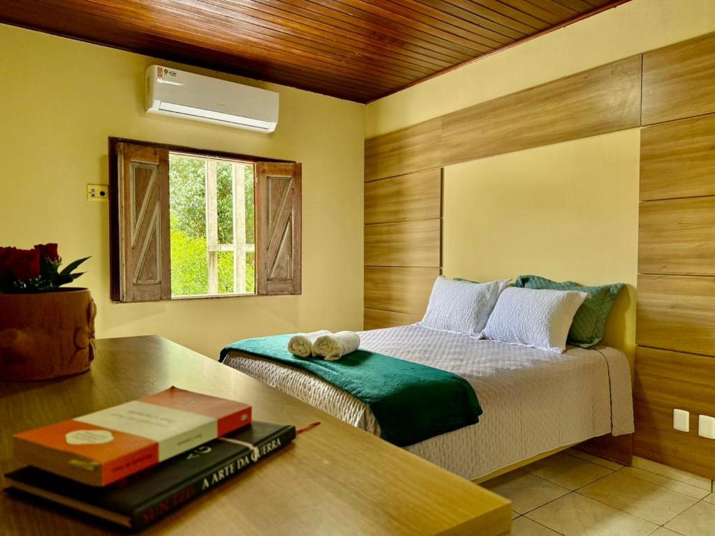 a bedroom with a bed and a table with a book at Refúgio Santarém in Barreirinhas