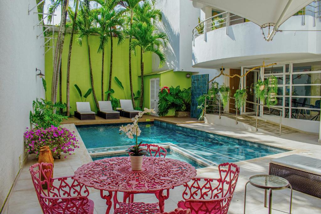 a patio with a table and chairs and a pool at Malik Hotel Boutique in Cali