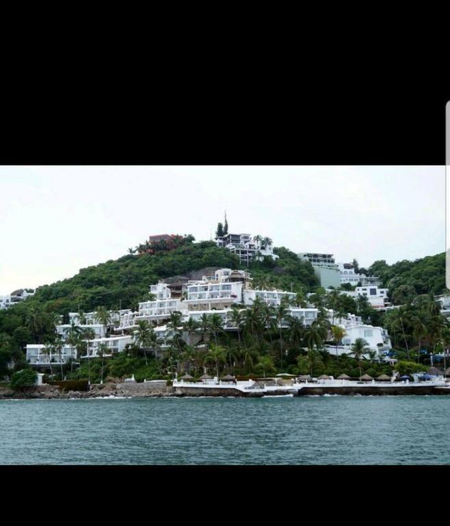 an island with white houses on a hill in the water at PlayaSol las Hadas in Manzanillo