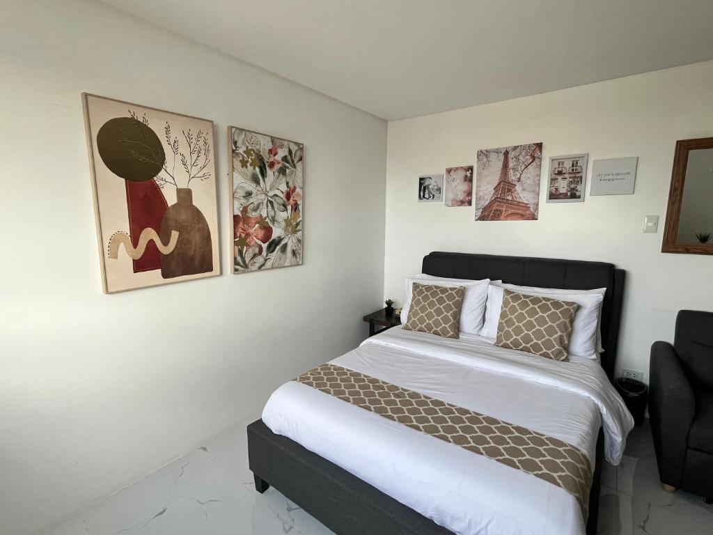 ein Schlafzimmer mit einem Bett und einigen Bildern an der Wand in der Unterkunft Luxee Haven in Manila