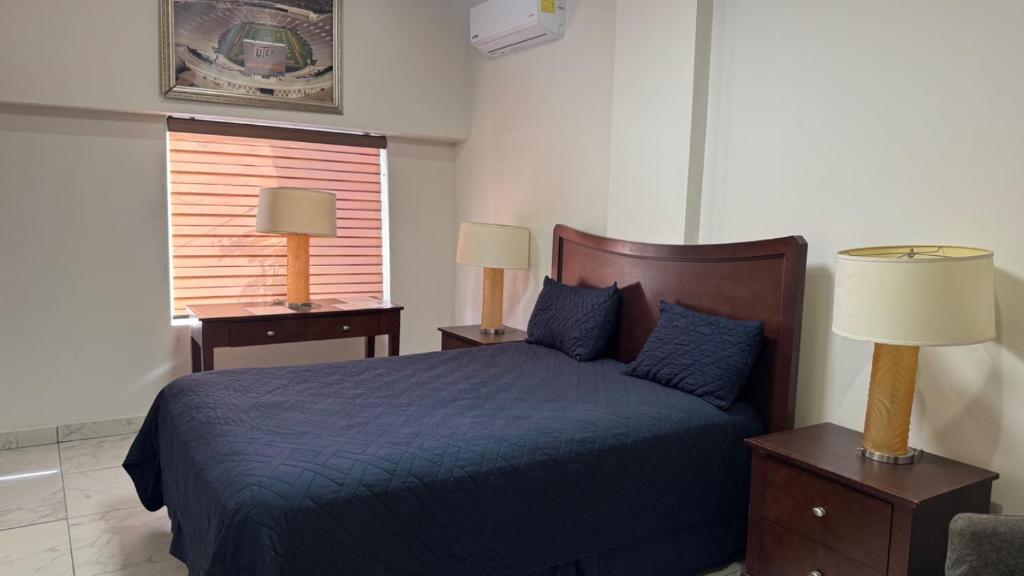 a bedroom with a blue bed and two night stands at Hotel La Frontera in Ciudad Juárez