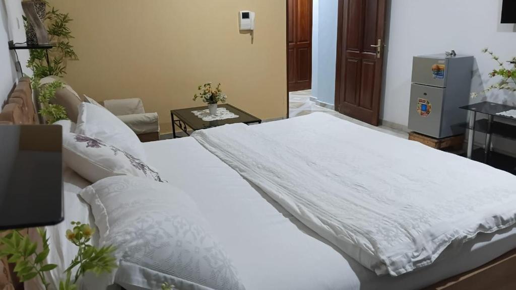 a bedroom with a large bed with white sheets at Providence Guest house and Catering Services 01 in Abidjan
