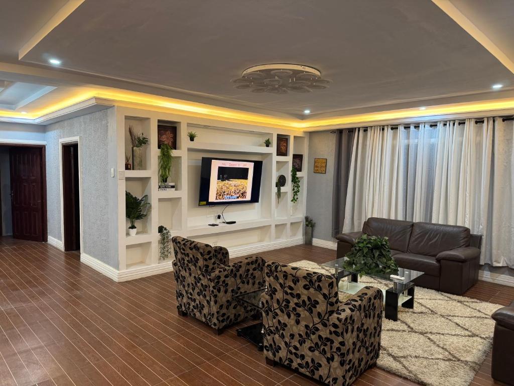 a living room with a couch and a tv at Raqsea House in Monrovia