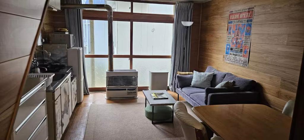 a living room with a couch and a table at The Lodge In Sapporo in Sapporo