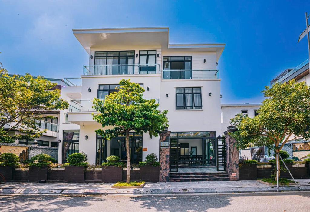 a white building with trees in front of it at LakeView Villa BT43-03 Sầm Sơn in Sầm Sơn