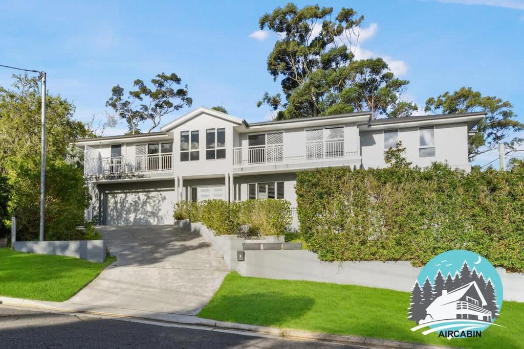 a large white house with trees and grass at 1B house beachside comfy stay in Collaroy