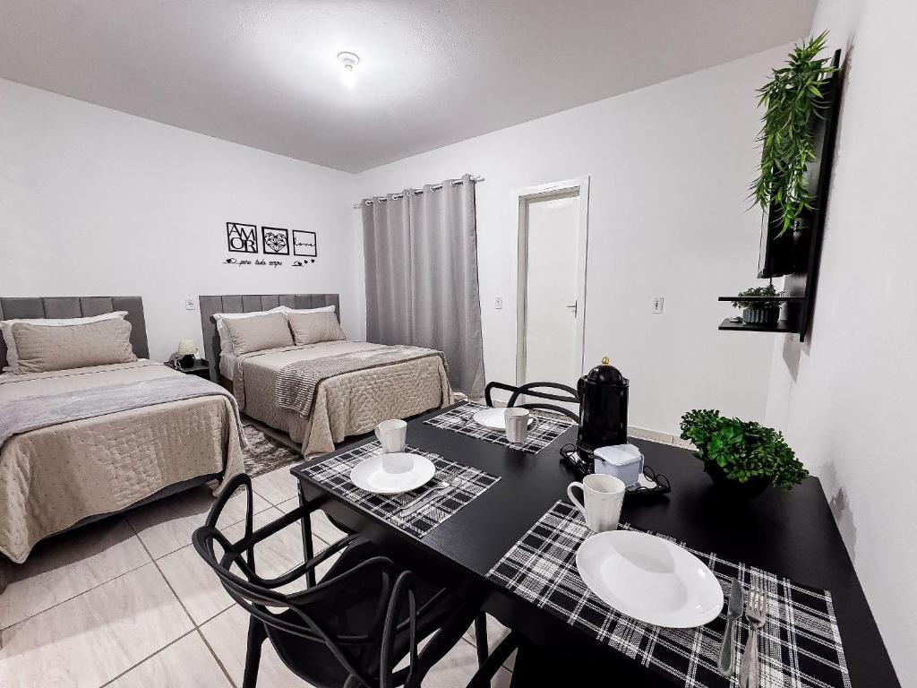 a living room with a table and a bed at Apê completo p/ 3 • vaga + Wi-Fi in Brusque