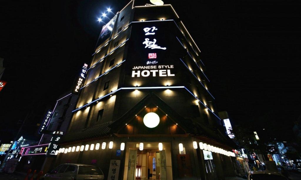 a building with a sign for a hotel at night at Daeheung Manwol Hotel in Daejeon