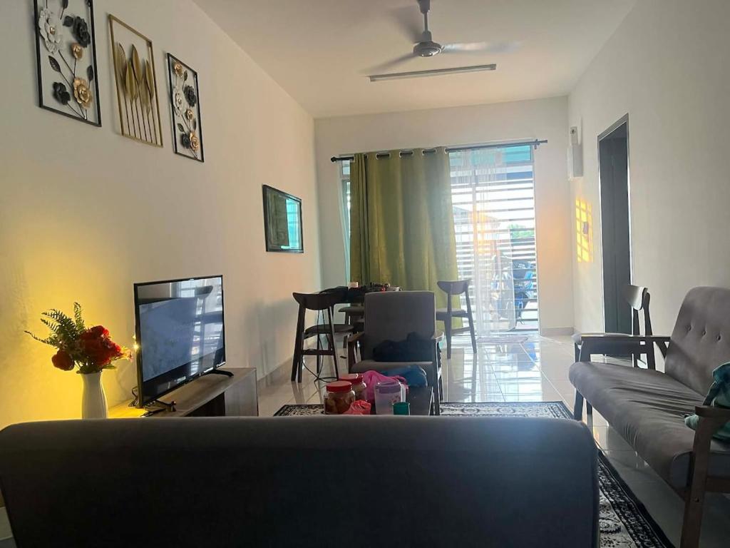 a living room with a couch and a television at Nady's Homestay in Banting