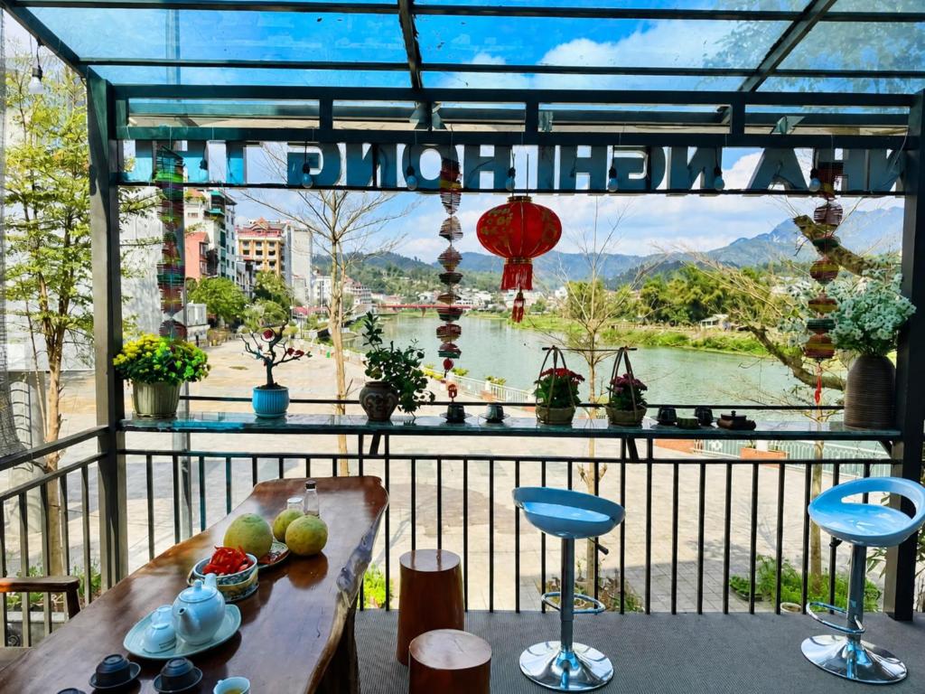 a balcony with a table and chairs and a view of a river at Hồng Thu Hotel Cao Bằng in Cao Bằng