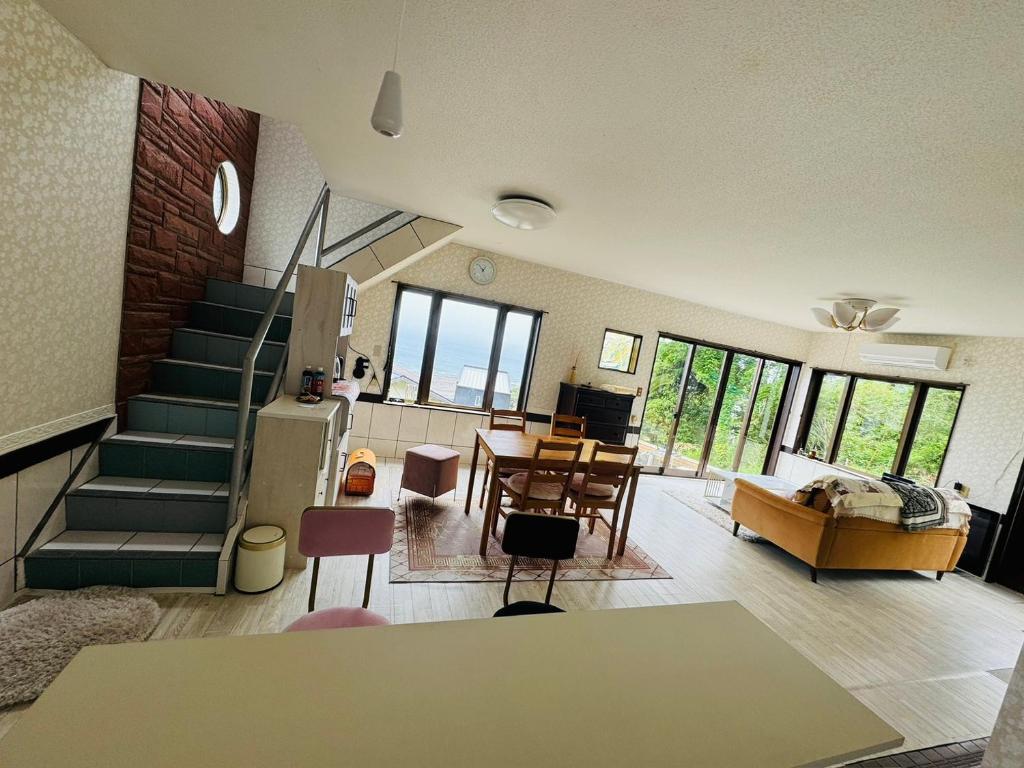 ein Wohnzimmer mit Treppe und ein Esszimmer in der Unterkunft Amoria in Miyazaki