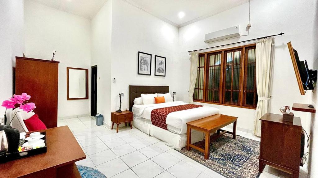 a bedroom with a bed and a desk in a room at Suite Room The Megatruh in Kejayan