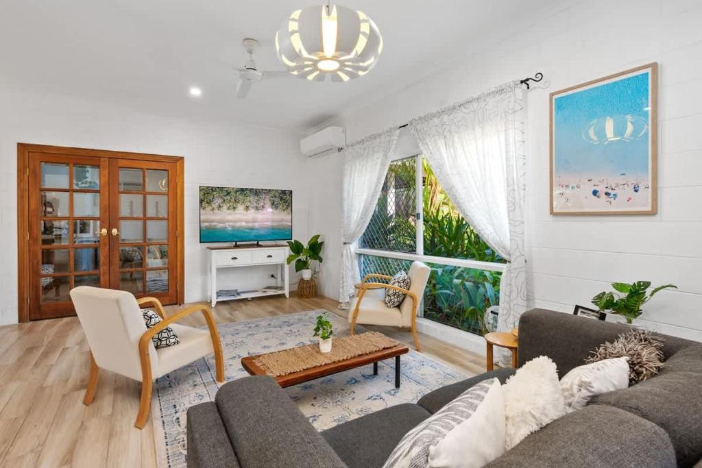 a living room with a couch and a table at Trinity Charm - Beachside Family Getaway with Pool in Trinity Beach