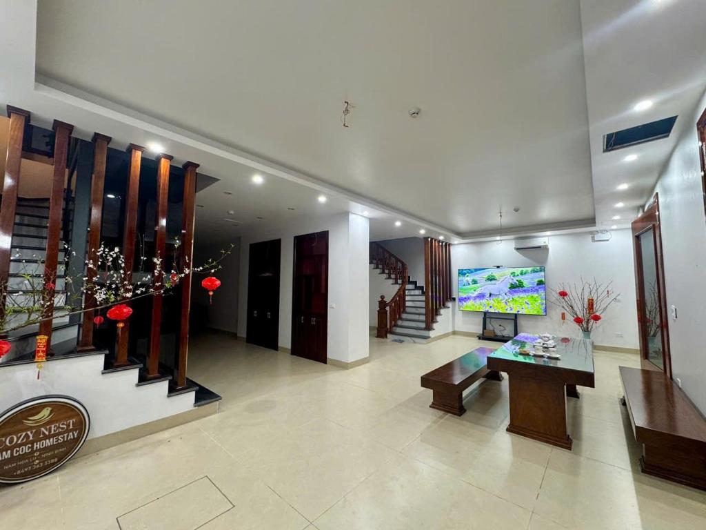 a lobby of a hotel with a television and stairs at Cong Hoa Homestay in Vũ Lâm