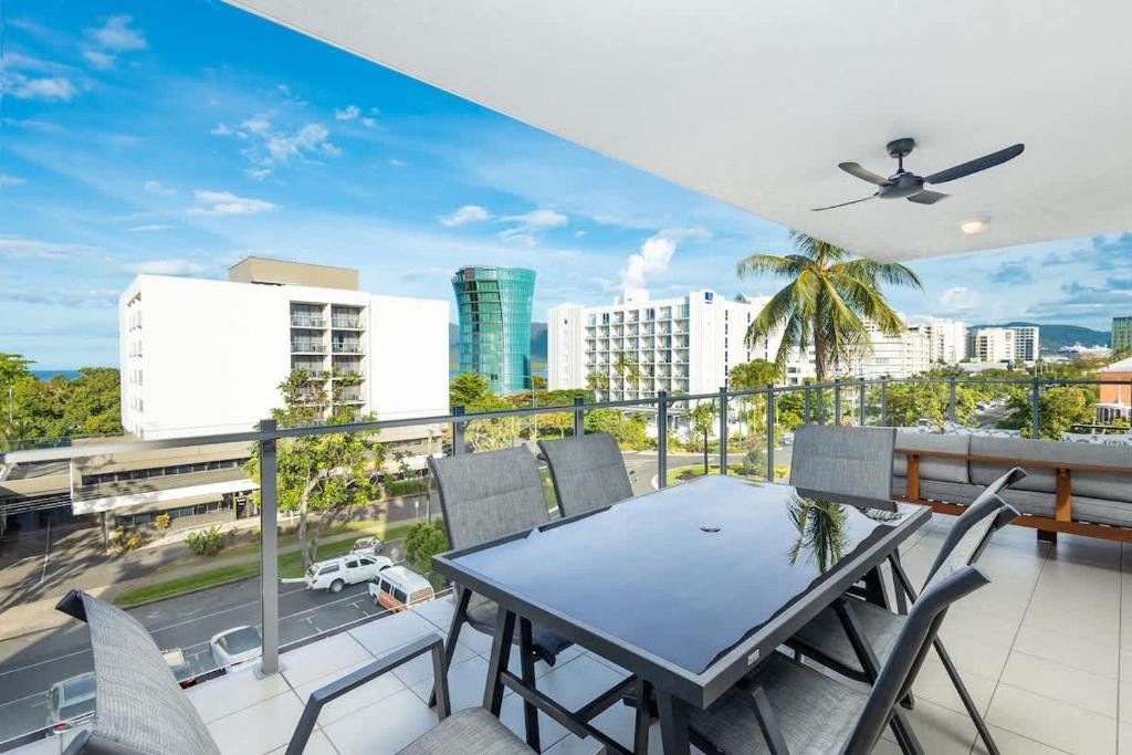 a balcony with a table and chairs and a city at Panorama Cairns - City & Coastal Views with Pool in Cairns