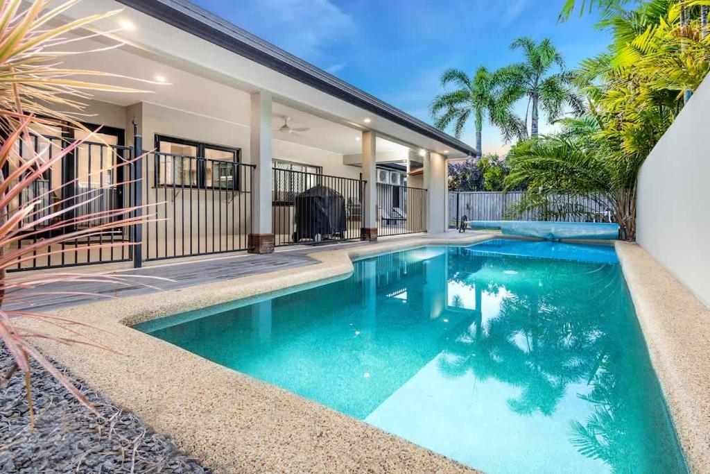 a swimming pool in front of a house at Tropical Pool Sanctuary in Kewarra Beach, Family and Dog Friendly in Kewarra Beach