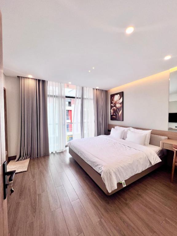 a bedroom with a large bed and a desk at SunQ Haven in Meyhomes in Phú Quốc