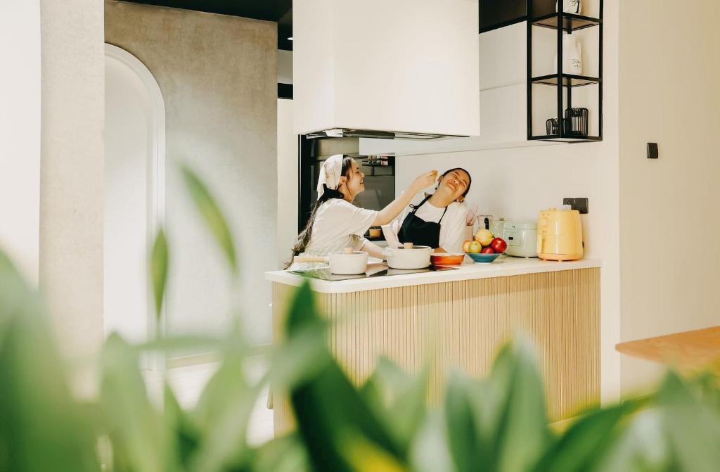 two women standing in a kitchen preparing food at SOMI House in Thôn Trường Giang