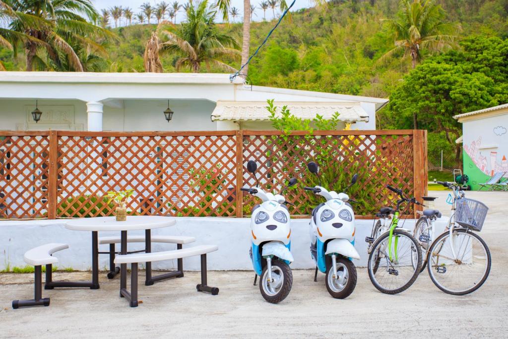 a group of scooters parked next to a table and bikes at Love Summer Hostel in Hengchun South Gate