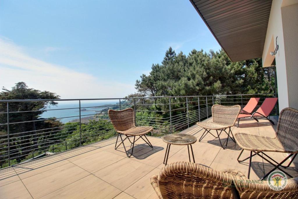 a patio with chairs and tables on a balcony at Brise marine in Trébeurden