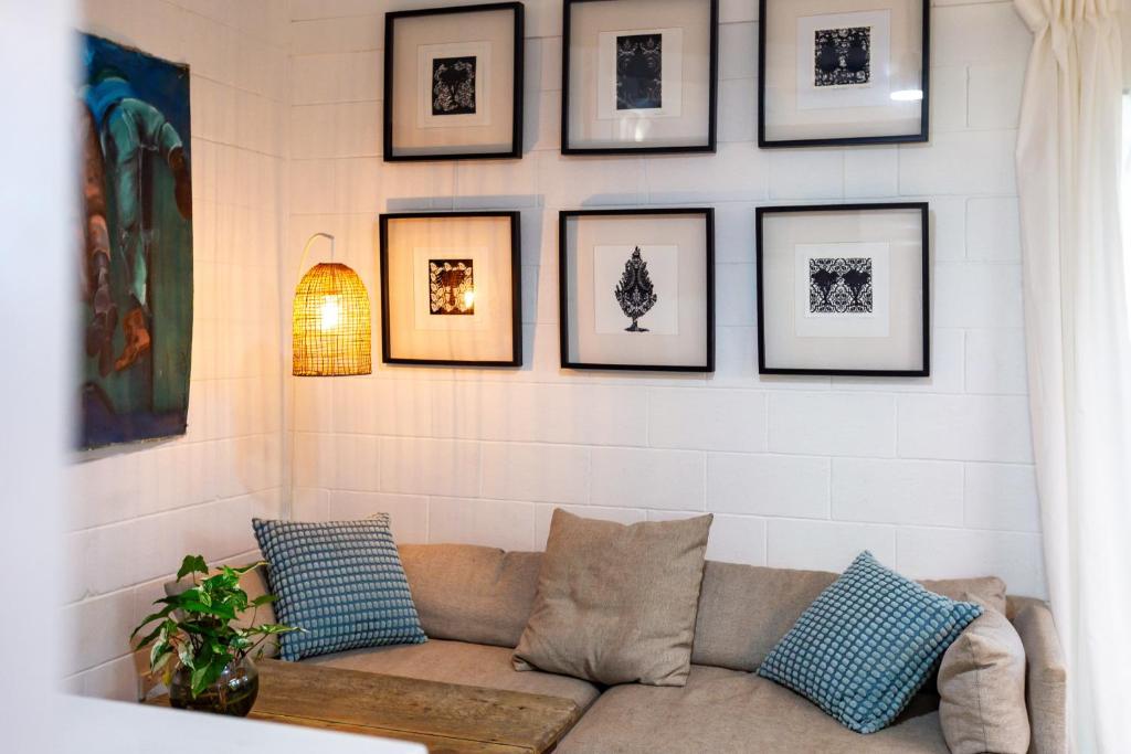 a living room with a couch and pictures on the wall at Studio 55 in Mudjimba