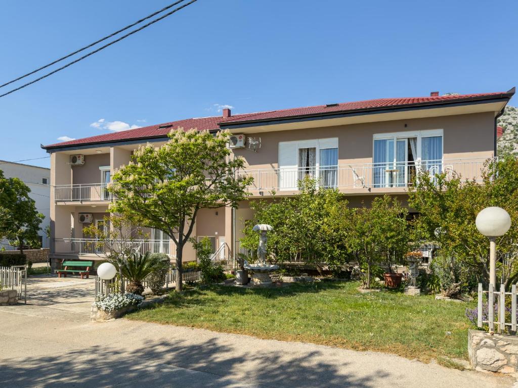 an apartment building with a yard in front of it at Tinka, Zimmer No 5 in Starigrad