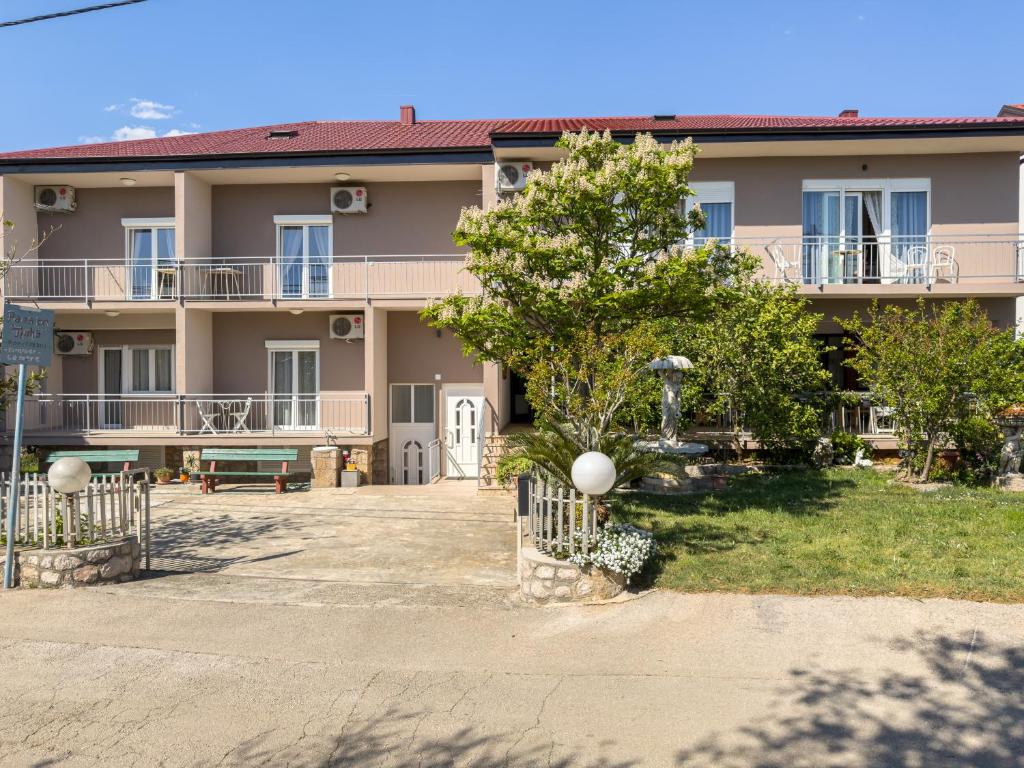 a large apartment building with a tree in front of it at Tinka, Zimmer No 6 in Starigrad