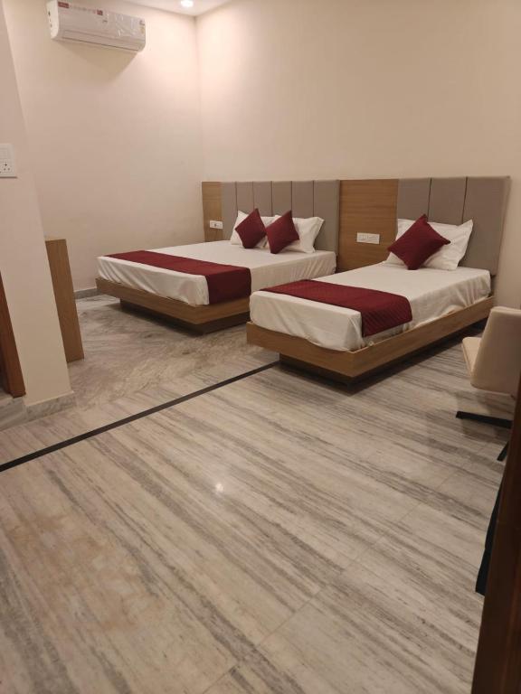 two beds in a room with wood floors at Blue Breeze in Haridwār
