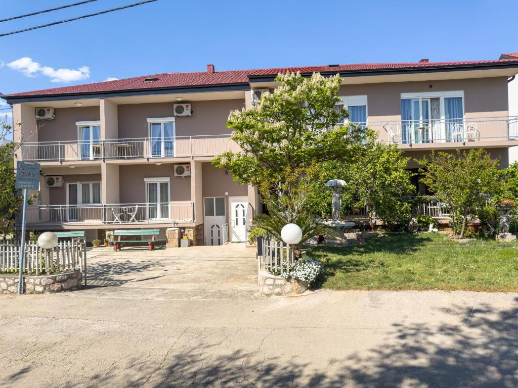 a large apartment building with a large yard at Tinka, Zimmer No 10 in Starigrad