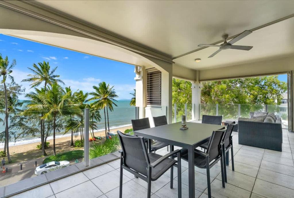 a dining room with a table and chairs and the ocean at The Marron Bloom - Beachfront Boutique Bliss in Palm Cove