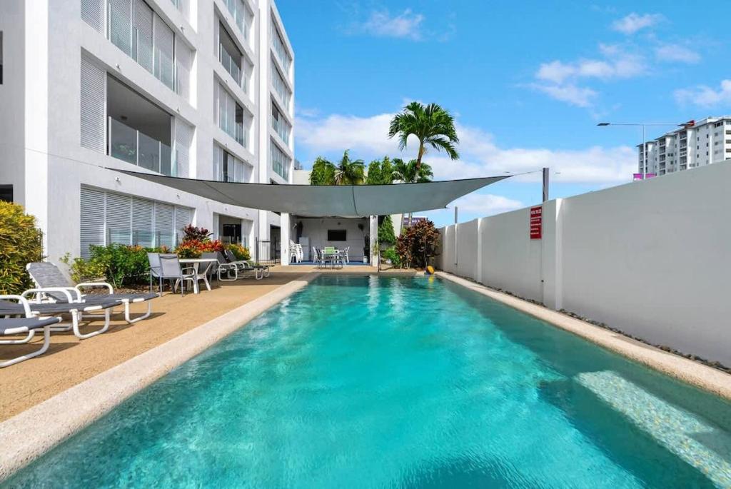 a swimming pool in front of a building at 'Eclipse' A Poolside Family Escape in the CBD in Cairns