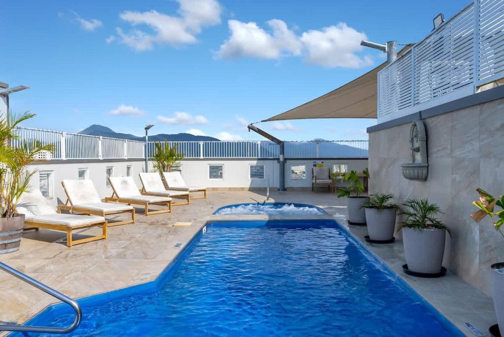 a swimming pool on a patio with chairs and a building at Peak Studio - Highview Haven across Shopping Centre in Cairns