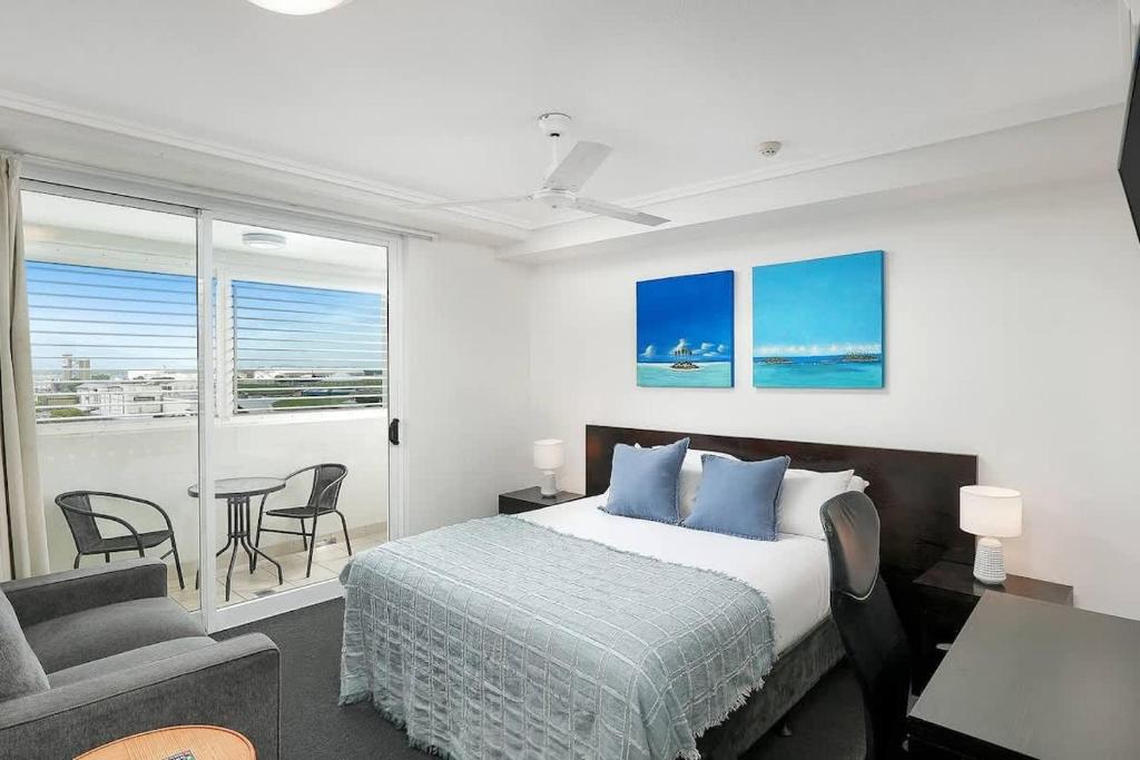 a bedroom with a bed and a table and chairs at 'Seaside Azul' A Central Studio with Rooftop Pool in Cairns