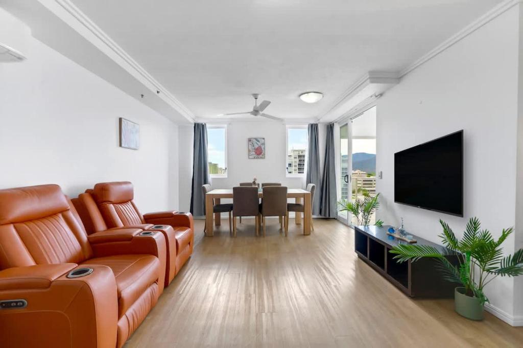 a living room with a couch and a dining room at McLeod Rise - Cairn Base with Rooftop Pool & Spa in Cairns