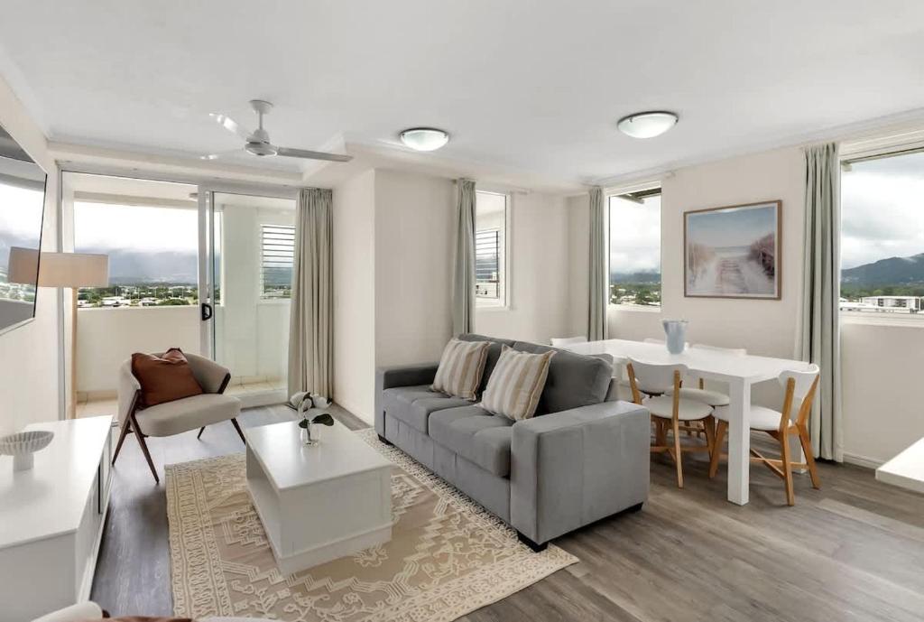 a living room with a couch and a table at Cairns Central Adjacent Suites, Steps to Esplanade in Cairns