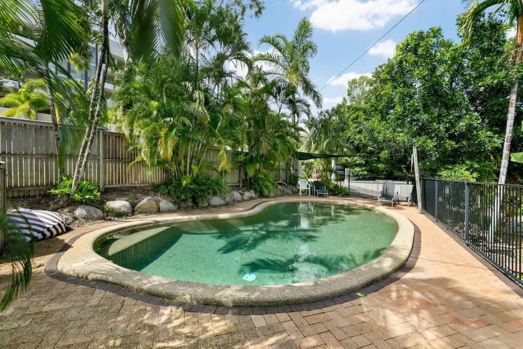 a small pool in a yard with a fence at Tropical Cove at Trinity Beach with Lagoon Pool in Trinity Beach