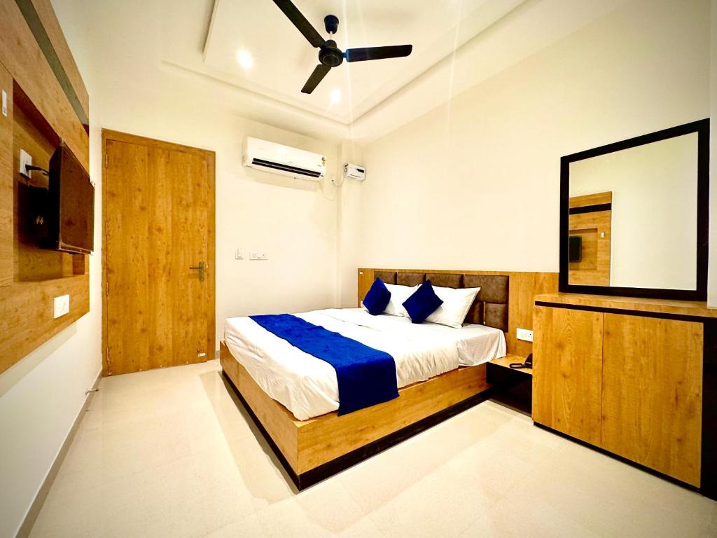 a bedroom with a bed and a flat screen tv at Vrind Orchid- Near Prem Mandir in Vrindāvan