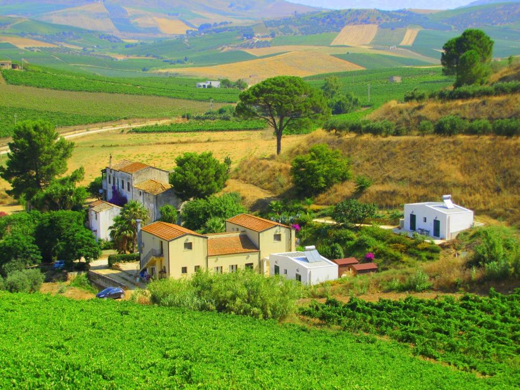 a small village on a hill in a green field at Agriturismo Tarantola in Alcamo