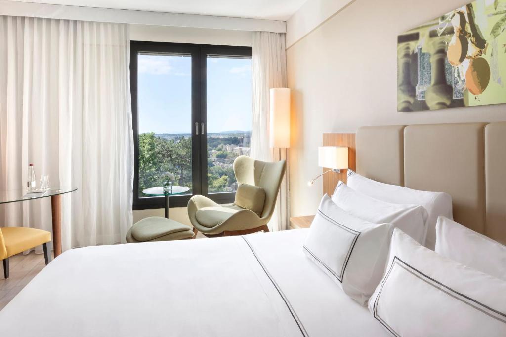 a hotel room with a bed and a window at Meliá Luxembourg in Luxembourg