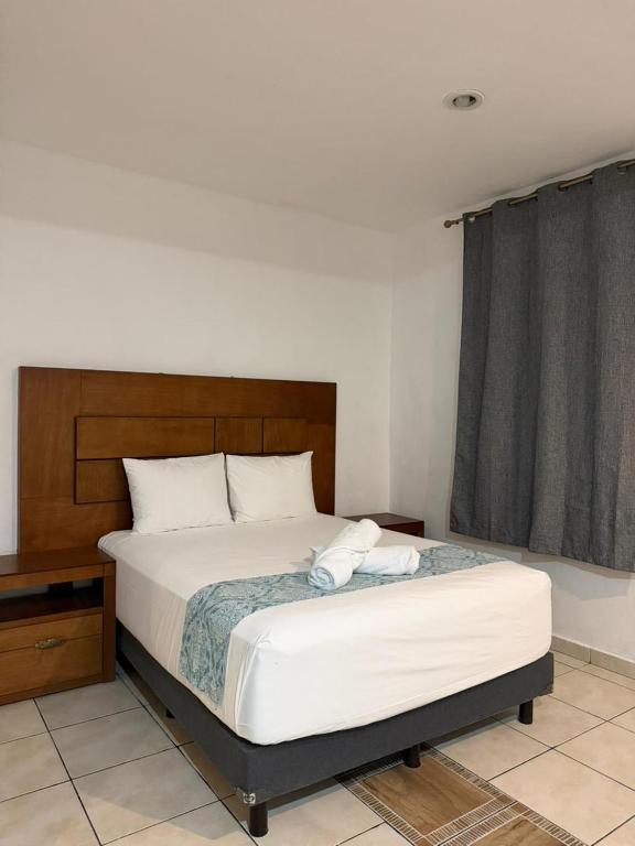a bedroom with a large bed with a wooden headboard at Casa Dixam Luum in Puerto Morelos