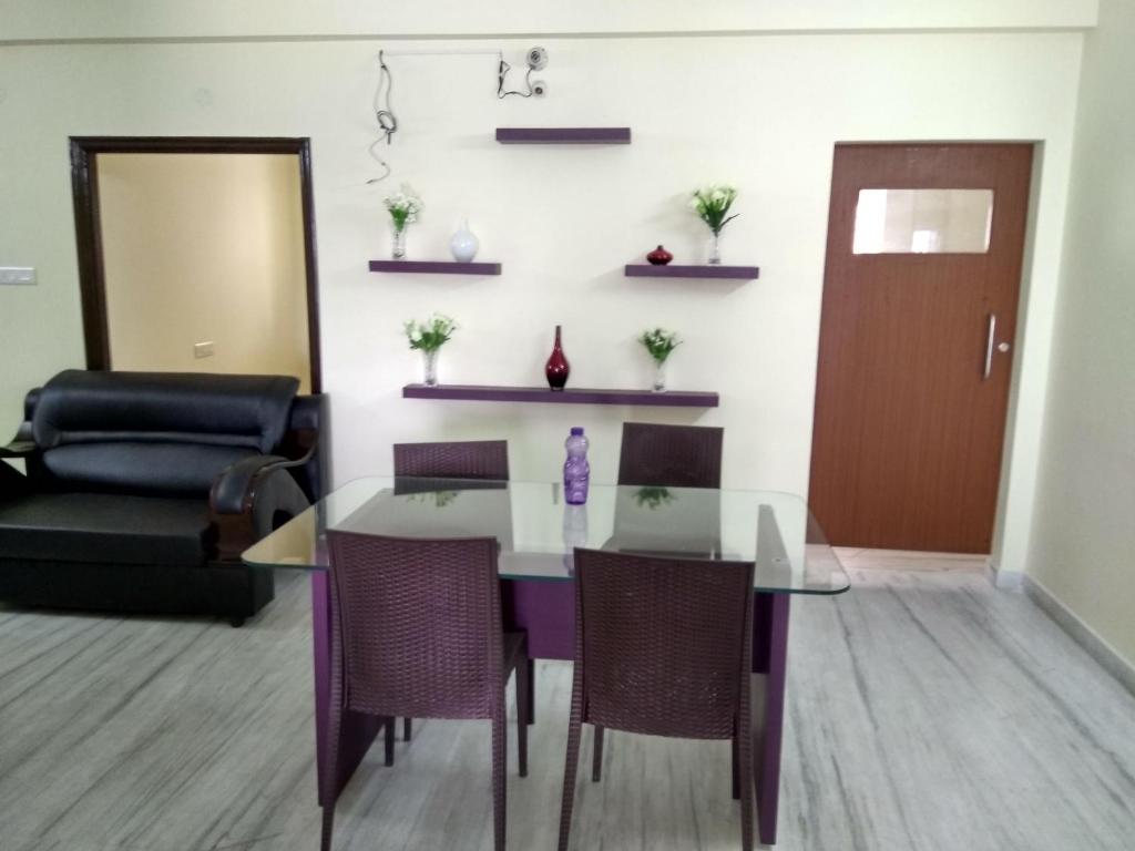 a dining room with a glass table and chairs at Mahas Inn in Hyderabad